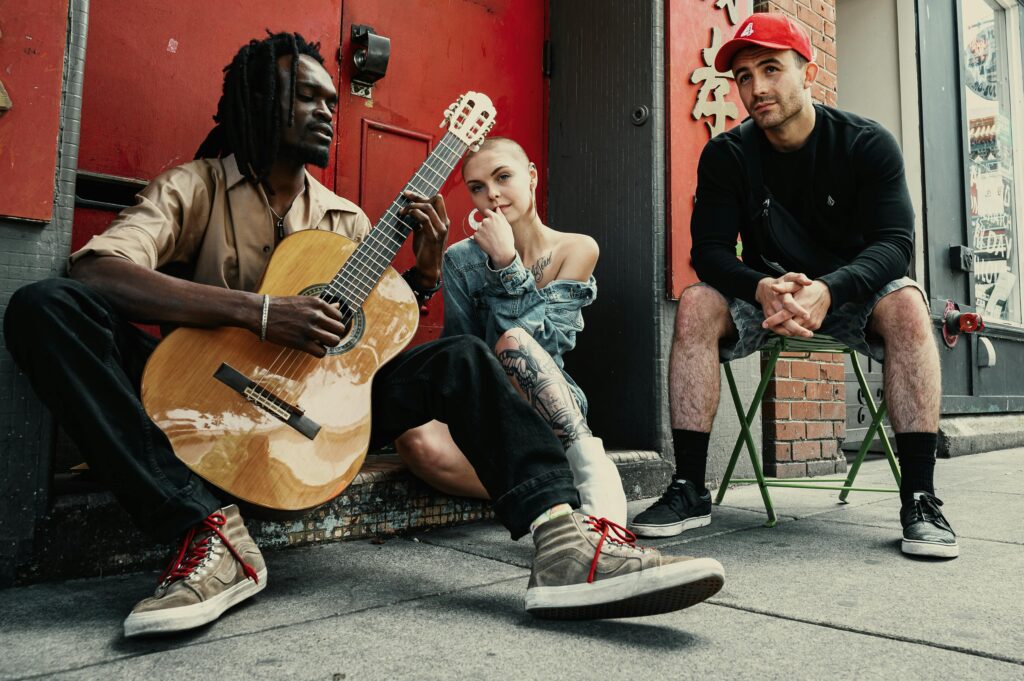 Diverse actors and musicians perform on a city street, showcasing their skills and busking as one of their side hustles..