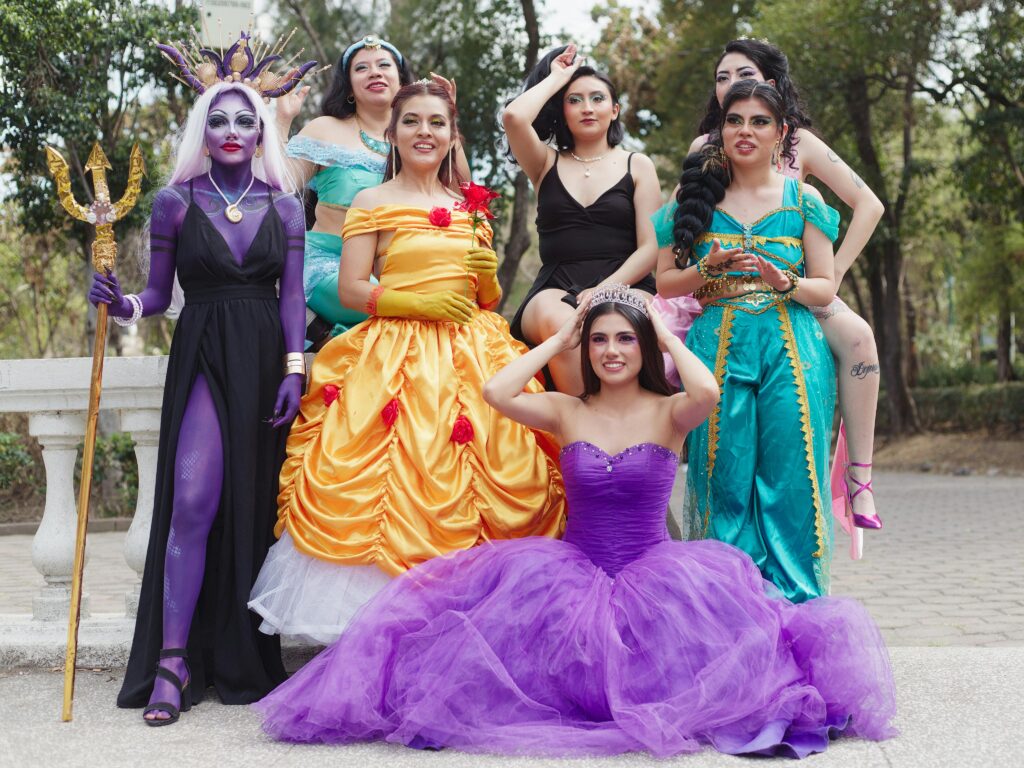 A group of female actors in Disney character costumes posing outdoors, embodying iconic princesses. They are performing Princess Parties as their side hustles.