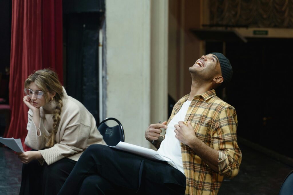 Two actors in acting classes rehearsing a scene in a theater, showcasing emotions and expression.