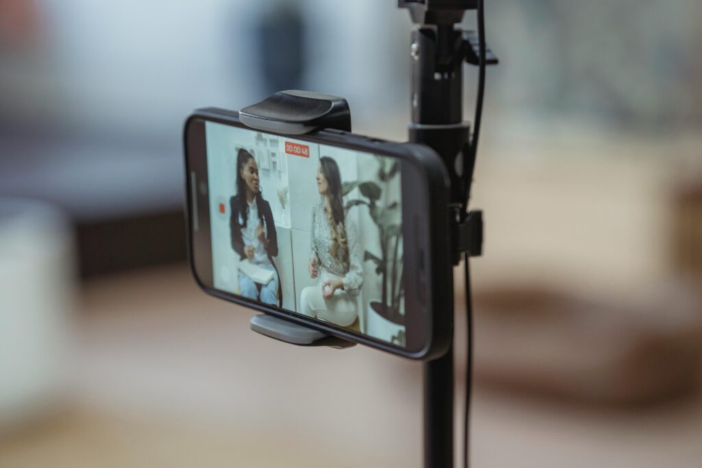 Modern smartphone on tripod recording video of actors creating content and treating it as free acting classes at the same time.