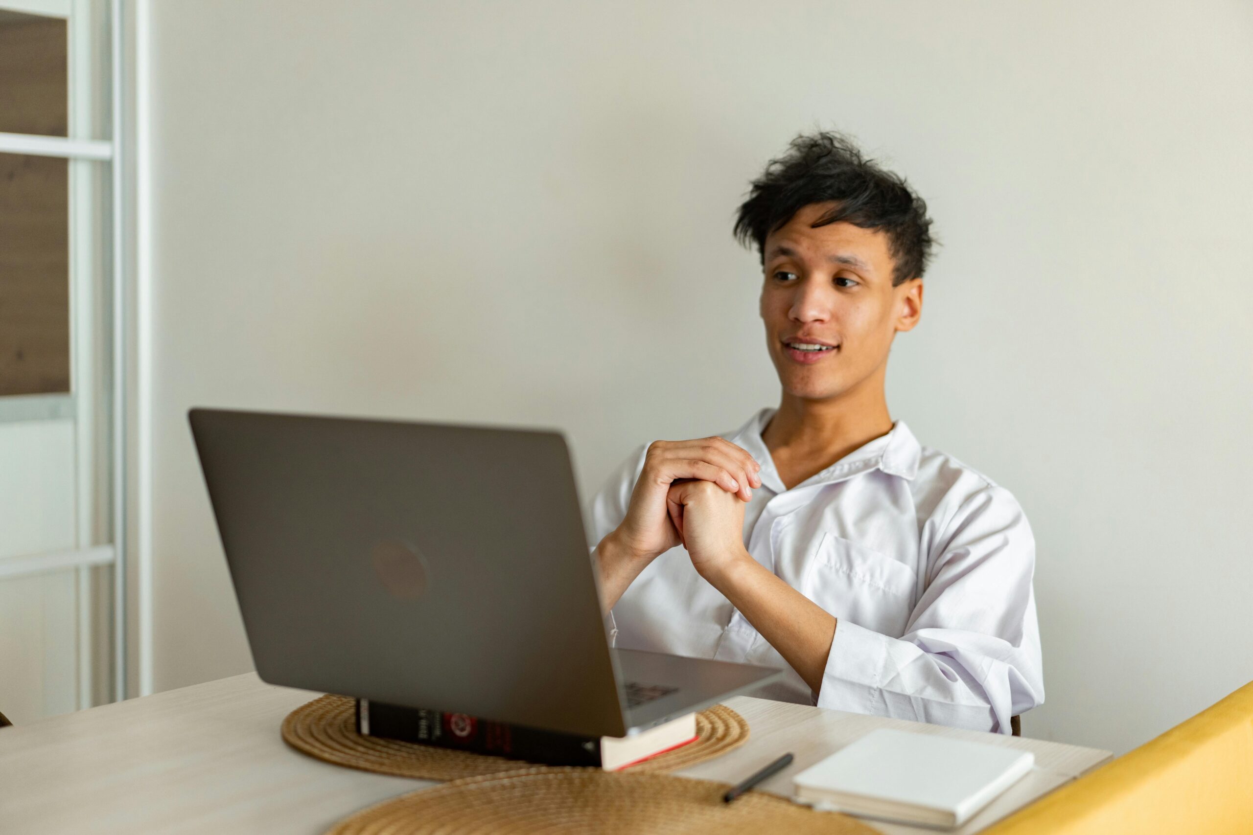 Actor in casual attire attentively participating in online acting classes from home.