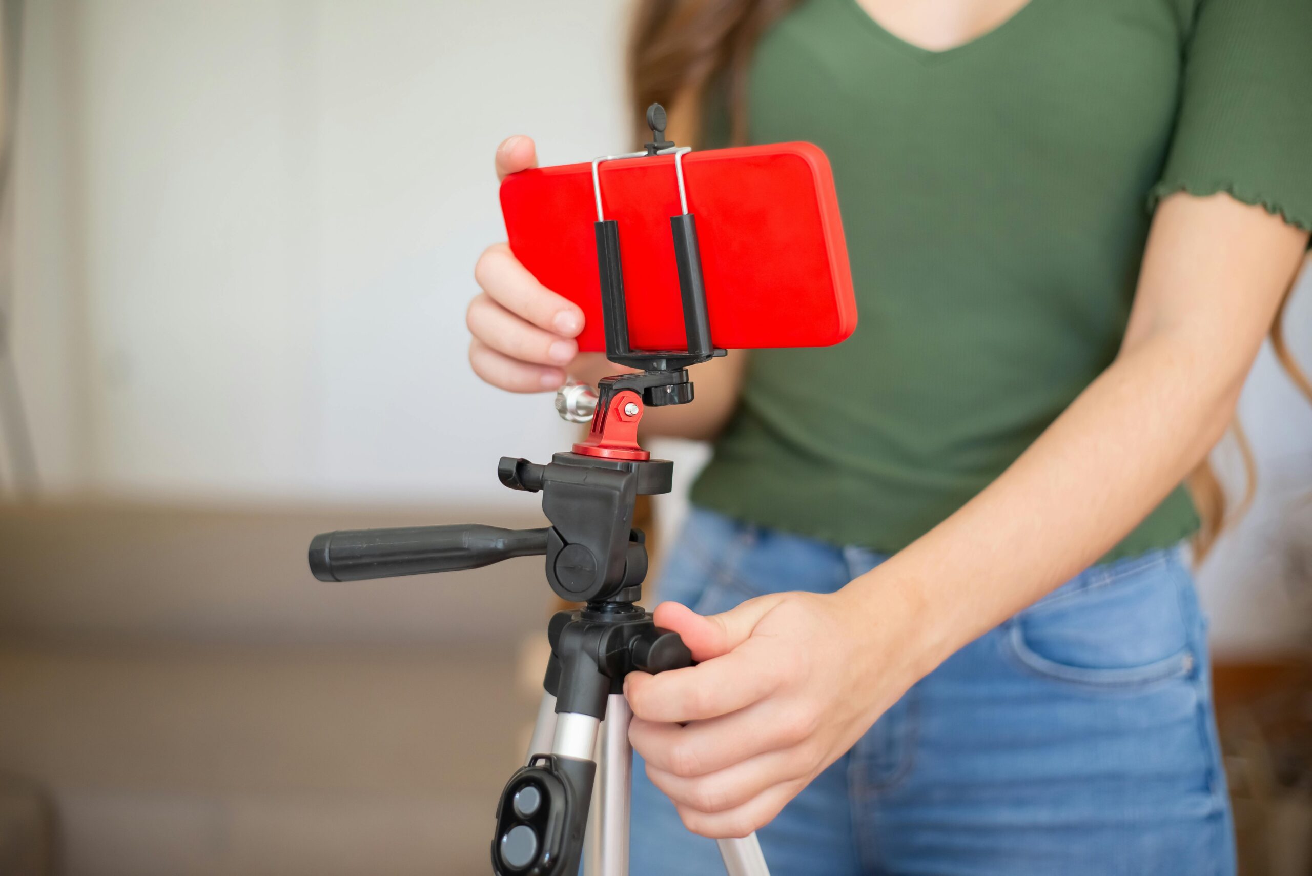 pexels-photo-7514811-7514811 actor adjusting smartphone onto tripod for recording indoors.